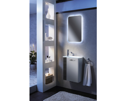 Modernes Badezimmer mit Waschtisch, beleuchtetem Spiegel und Regal