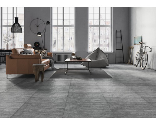 Wohnraum mit Sofa, Couchtisch, Sitzsack und grauem Bodenbelag