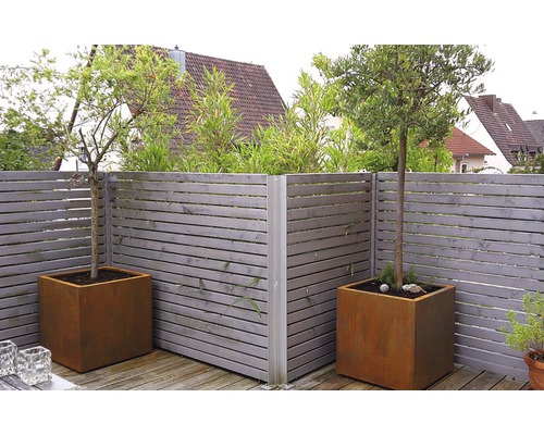 Gartenszene mit Holzzaun und Pflanzenkübeln