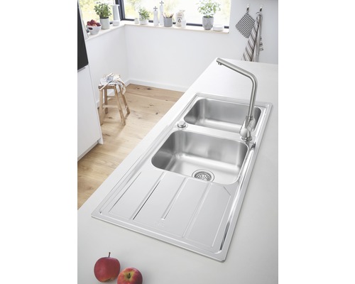 Küchenspüle aus Edelstahl mit Abtropffläche und Wasserhahn in einer hellen Küche