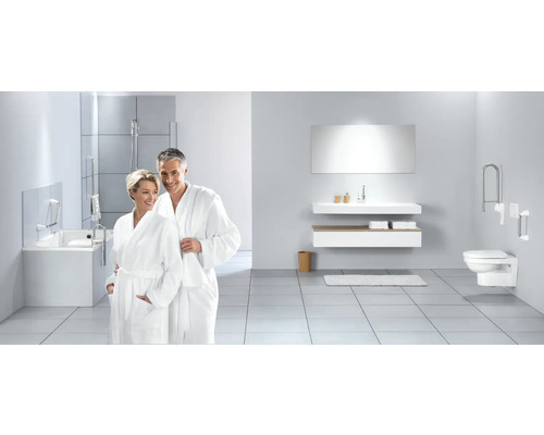 Barrierefreies Badezimmer mit Badewanne, Waschtisch und Toilette sowie einem Paar in Bademänteln