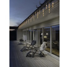 Außenansicht eines Hauses mit Eisregenlichterkette, Gartenmöbeln und Terrasse.