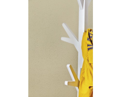 Weiße Garderobe mit gelber Jacke vor einer Wand