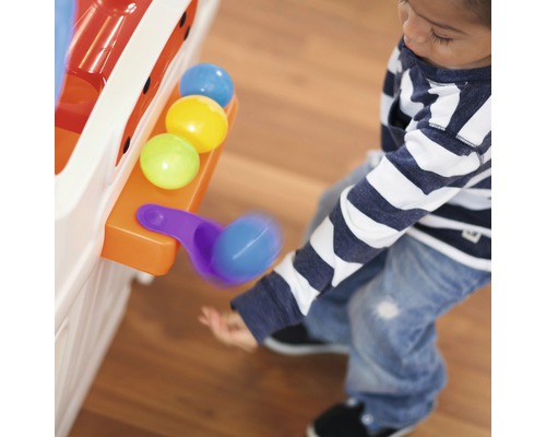 Kind spielt mit einem Ballspielzeug mit bunten Bällen und einer Schaufel