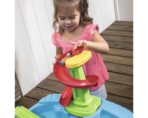 Mädchen spielt mit Wasserrutsche am Sand- und Wasserspieltisch