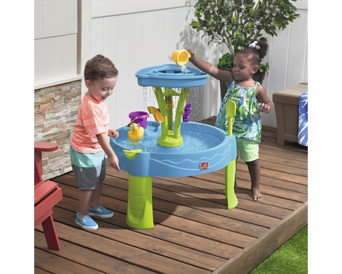 Zwei Kinder spielen mit einem Step2 Waterfall Discovery Wall Spieltisch im Freien mit Zubehör.