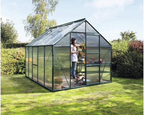 Gewächshaus Vitavia Meridian 1 8300 Hohlkammerplatten 6 mm 257x321 cm smaragd Gewächshaus im Garten mit einer Frau, die Pflanzen pflegt