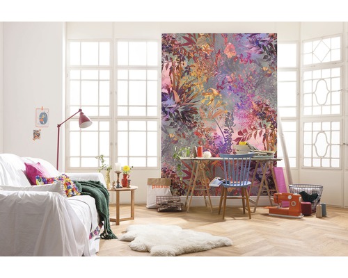 Wohnzimmer mit floraler Fototapete, Sofa und Arbeitstisch vor einem Fenster