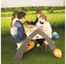 Kinder sitzen an einem Kinderspieltisch im Freien