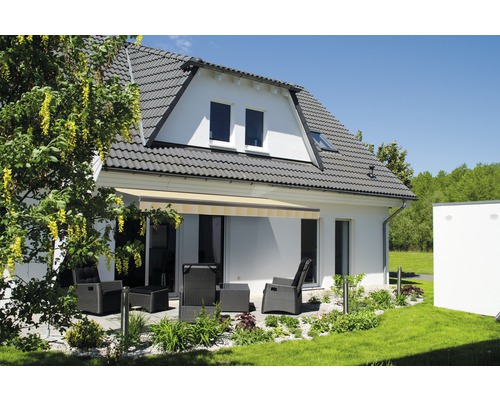 Hausfassade mit Markise und Gartenmöbeln auf der Terrasse