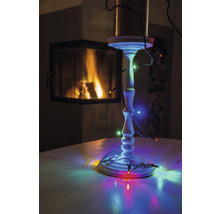 Kerzenständer mit Lichterkette und Kamin im Hintergrund