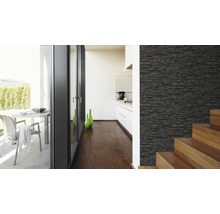 Heller Raum mit einer Wand in Steinoptik, Treppe und Blick auf eine Terrasse