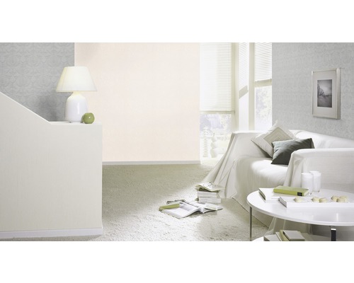 Wohnzimmer mit Sofa, Tisch, Lampe und Mustertapete