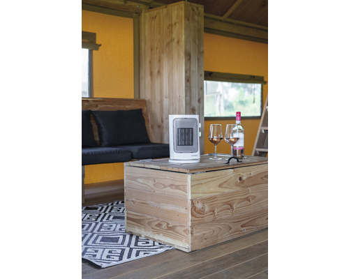Innenraum mit Holzmöbeln, einem tragbaren Heizgerät und zwei Gläsern Wein auf einem Holztisch