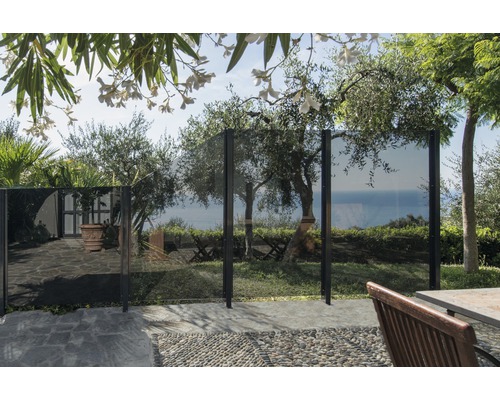 Gartenszene mit Windschutz aus Glas und Metall