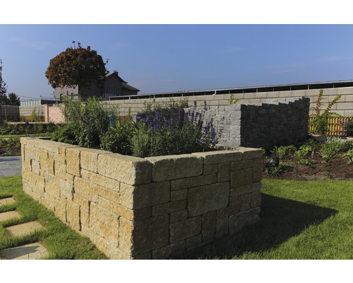 Gartenlandschaft mit bepflanztem Steinbeet und Trockenmauer