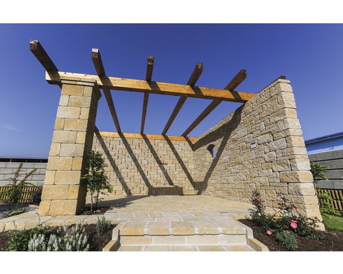 Außenbereich mit Steinmauer und Holzpergola
