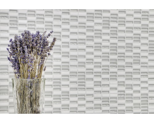 Dekorative Wand mit Glasmosaikfliesen und einem Lavendelstrauß in einer Vase