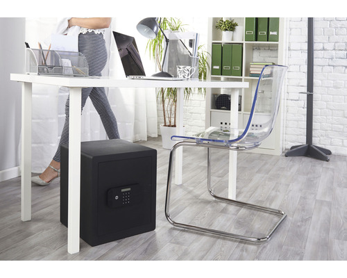 Büroszene mit einem schwarzen Möbeltresor unter einem Schreibtisch