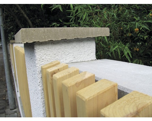 Detailansicht eines Gartenzauns mit Betonpfosten und Holzelementen