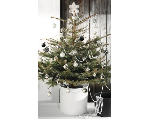Geschmückter Weihnachtsbaum im Topf mit Christbaumkugeln und Girlanden