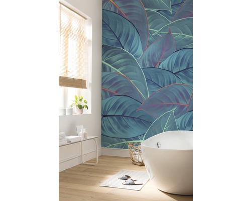 Badezimmer mit Badewanne, Fenster und Wandtapete mit Blattmotiv