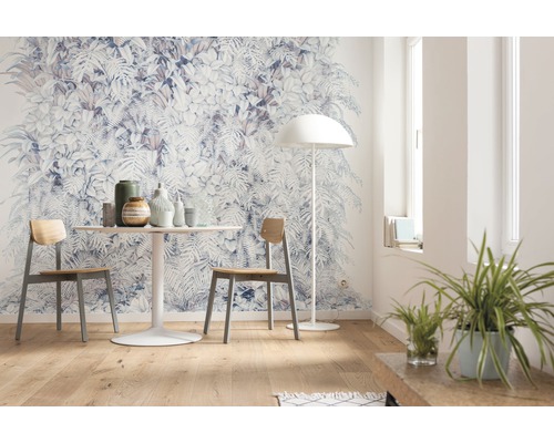 Wohnraum mit botanischer Tapete, Tisch, Stühlen und Stehlampe