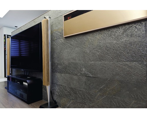 Wohnzimmer mit Fernseher, Lautsprechern und Wandverkleidung aus Stein