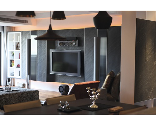 Wohnzimmer mit Fernseher, Lautsprechern und Regalen für ein modernes Wohnambiente