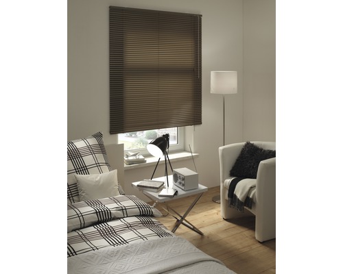 Schlafzimmer mit brauner Jalousie am Fenster, Bett, Sessel und Stehlampe