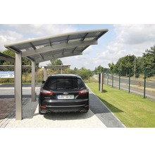 Ein Auto steht unter einem Carport auf einem Parkplatz.