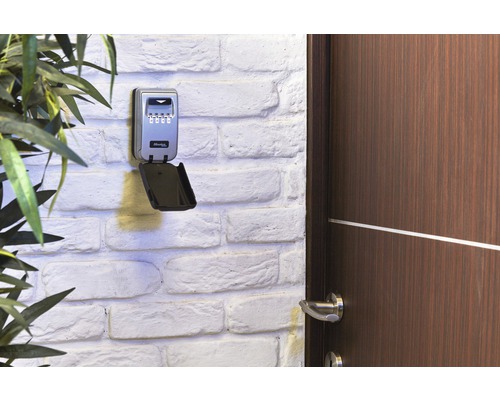 Schlüsseltresor mit Zahlencode an einer Wand neben einer Tür.