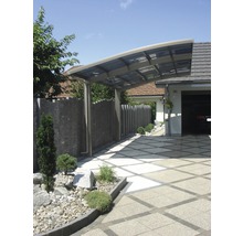 Modernes Carport aus Metall neben einer Garage und einem gepflasterten Weg
