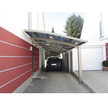 Auto unter einem Carport neben einem Haus mit Garage