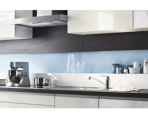 Küchenszene mit Dunstabzugshaube, Küchenmaschine, Spüle und Kochfeld in einem modernen Küchendesign.