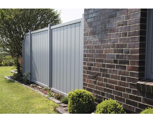 Gartenzaun aus Metall neben einem Backsteingebäude