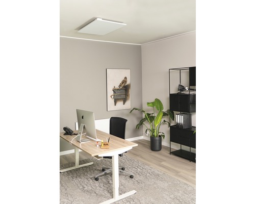 Büro mit Infrarotheizung an der Decke, Schreibtisch und Regalen für ein angenehmes Arbeitsumfeld.