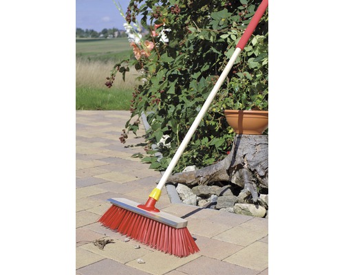 Kehrbesen mit Stiel zum Reinigen von Pflasterflächen im Garten.