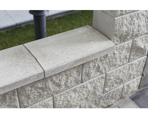 Detailansicht einer Mauer aus Betonsteinen mit Mauerabdeckung