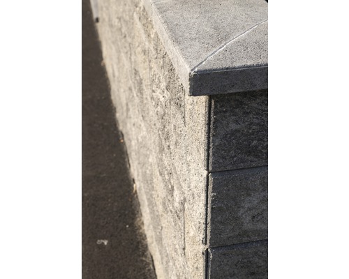 Nahaufnahme einer Mauer aus Betonsteinen mit Abdeckung