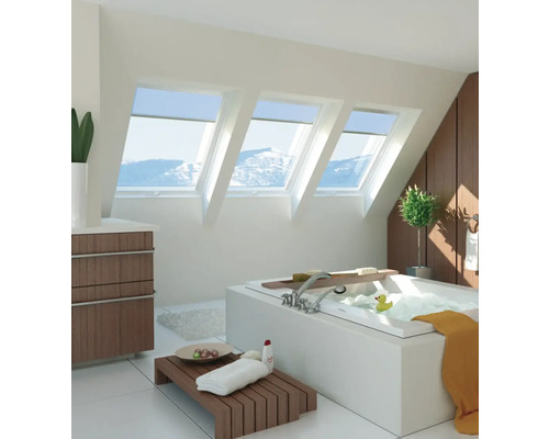 Helles Badezimmer mit Dachfenstern, Badewanne und Holzdetails