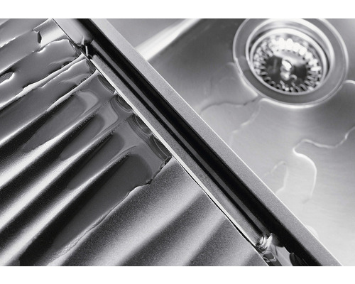 Detailansicht eines Spülbeckens aus Edelstahl mit Abtropffläche und Ablaufgarnitur