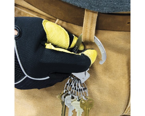 Eine Hand mit Arbeitshandschuh befestigt einen Schlüsselanhänger mit mehreren Schlüsseln am Gürtel