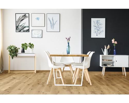 Esszimmer mit Esstisch, Stühlen und Dekorationen in einem hellen Raum