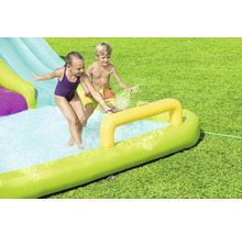 Aufblasbare Wasserrutsche mit spielenden Kindern im Garten.