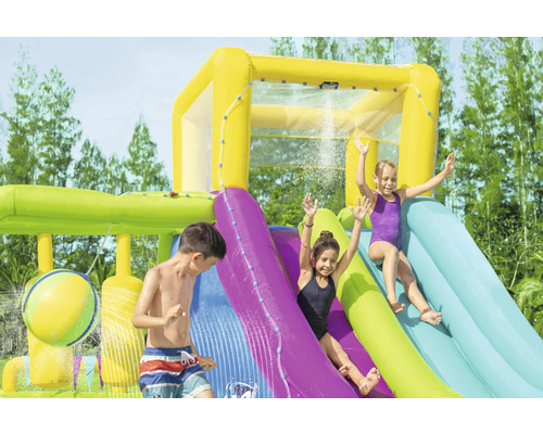 Aufblasbare Wasserrutsche mit spielenden Kindern im Garten