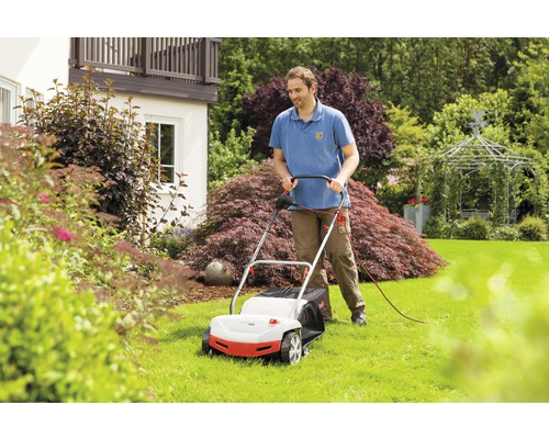 Mann verwendet einen Rasenmäher im Garten.