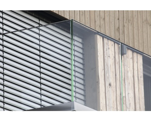 Detailaufnahme eines Balkons mit Glasgeländer und Holzverkleidung