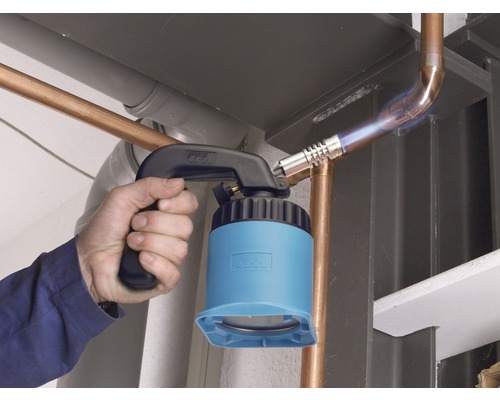 Eine Person lötet mit einem Lötbrenner ein Kupferrohr.