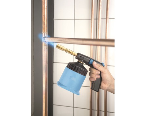 Ein Mann lötet mit einem Lötbrenner Kupferrohre.